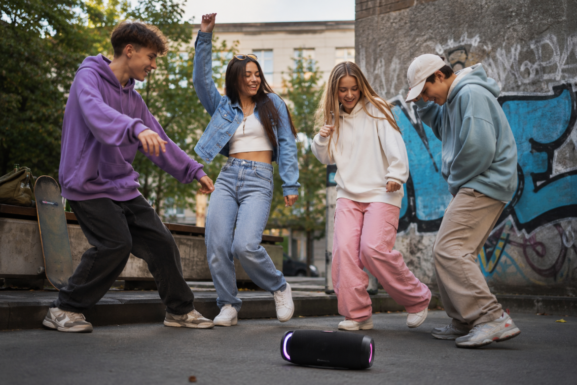 Група підлітків танцює на вулиці біля Bluetooth-колонки